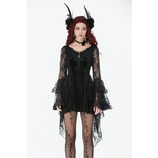 Gothic model wearing a black lace dress with long sleeves and sheer tights on a white background