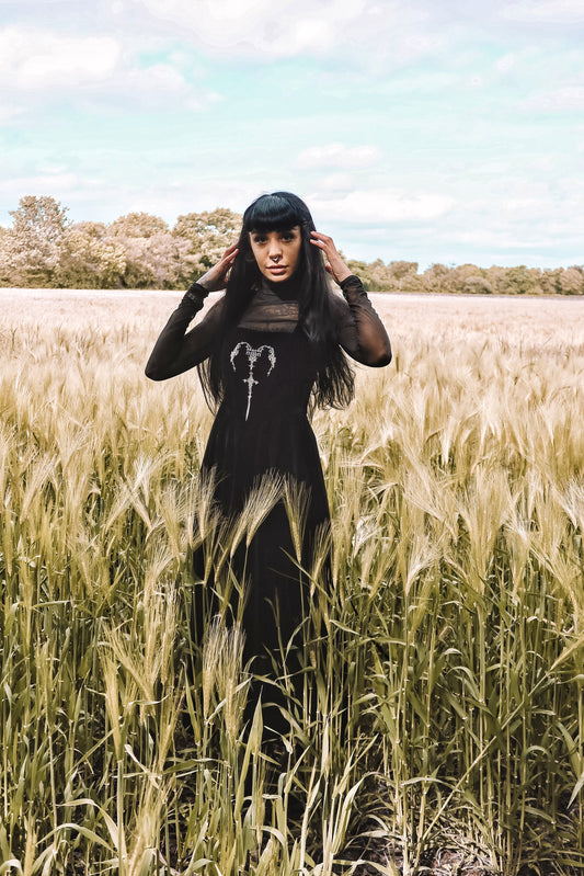 PJ the Heathen alternative model wearing a Dark in Love Gothic Velvet Maxi Dress styled over a long sleeve mesh top