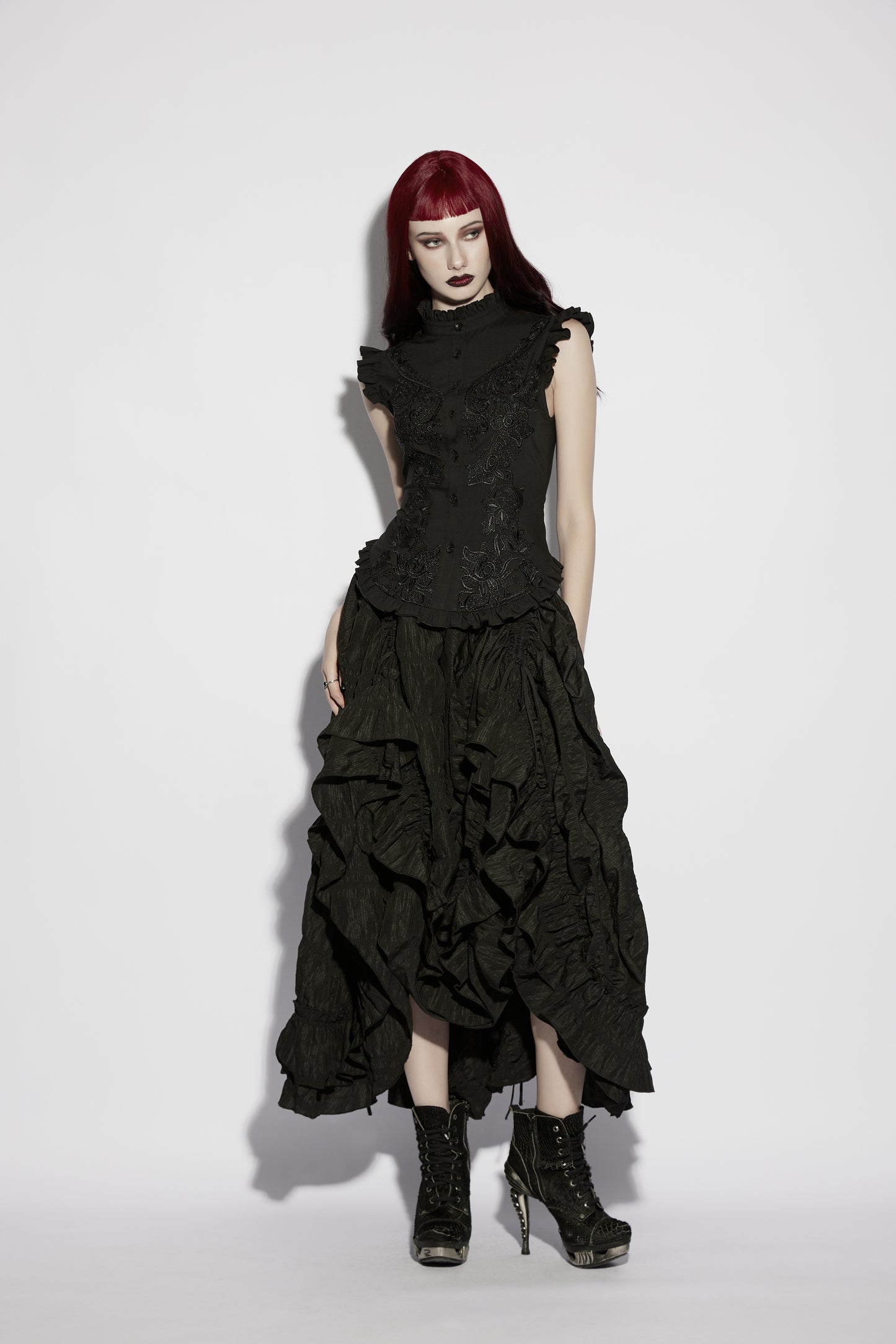 Goth ruffle shirt model wearing Punk Rave Elara Top with ruffle skirt and black boots, showcasing gothic fashion style.