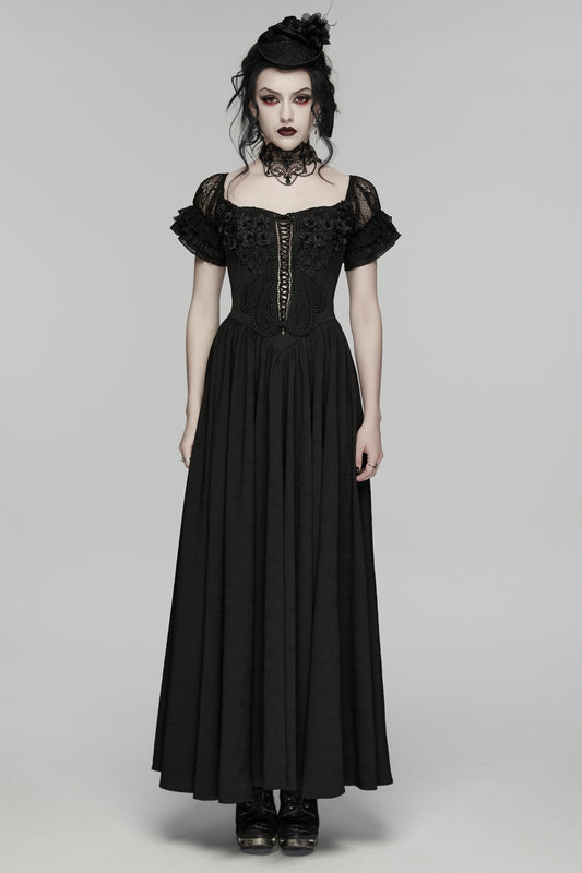 Woman wearing a black gothic-style dress on a gray background