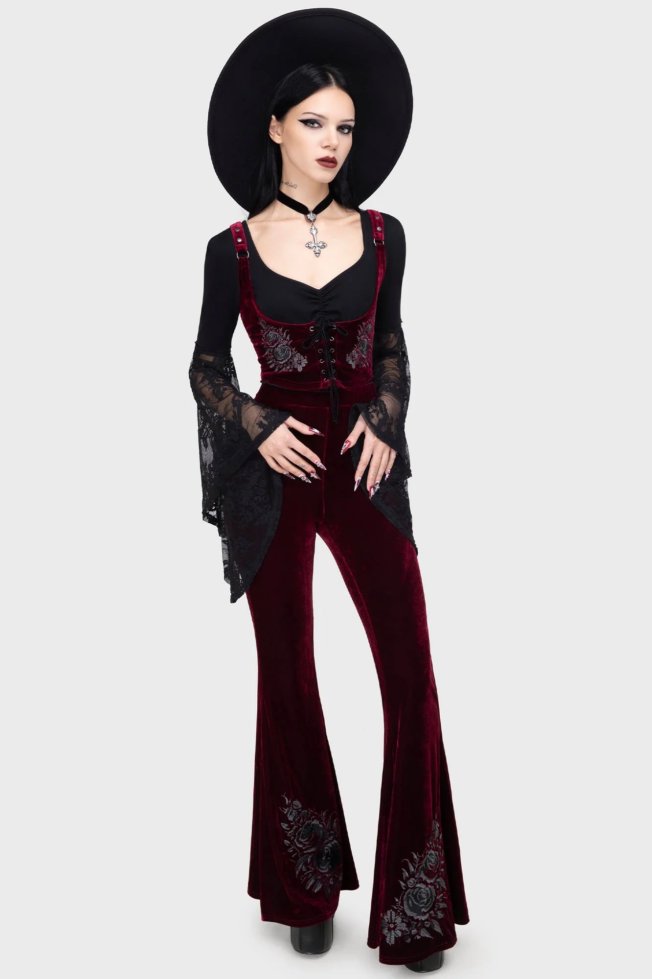 Woman wearing a black and red outfit with floral embroidery on a white background