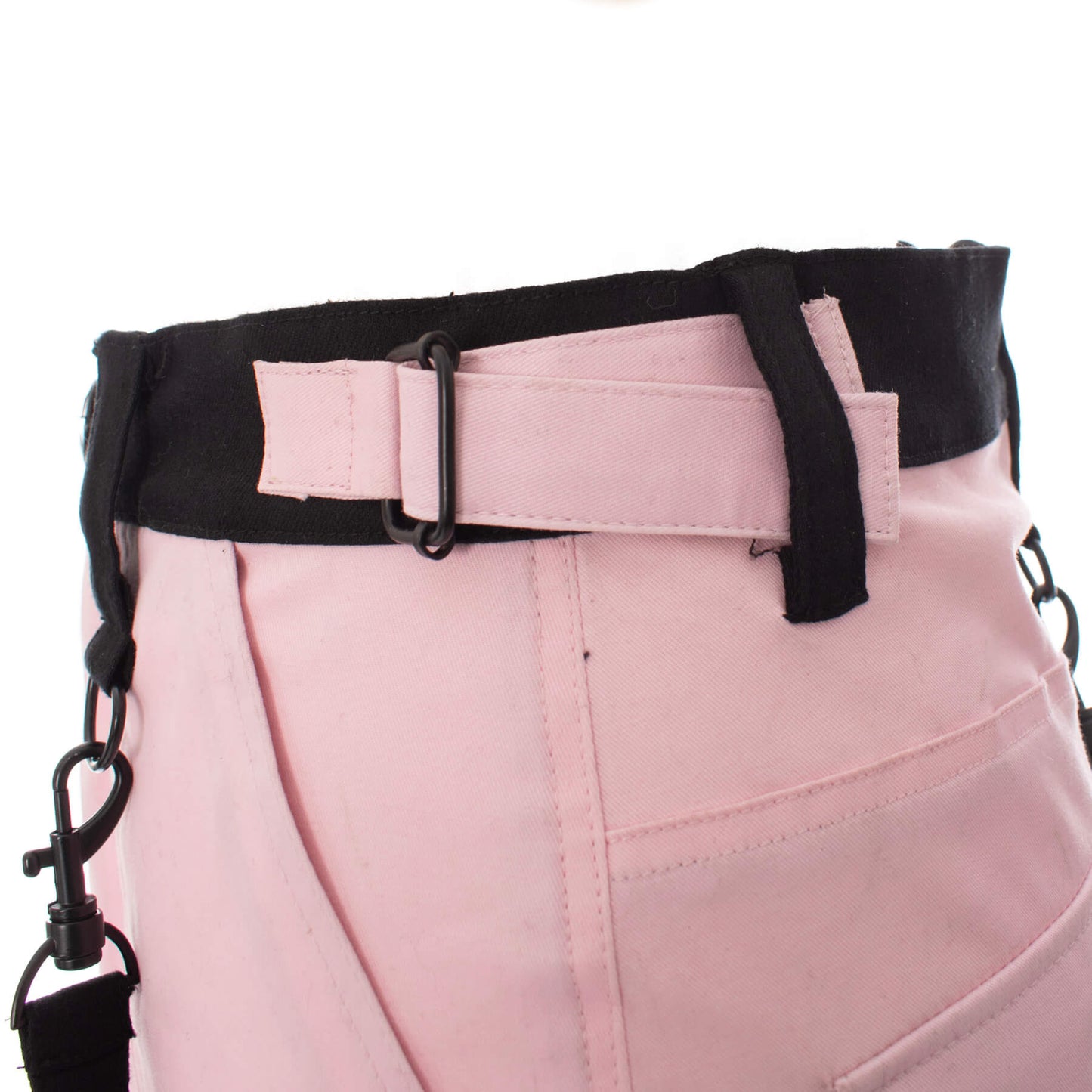 Close-up of a gothic mini skirt showing black and pink strap detail and adjustable belt.