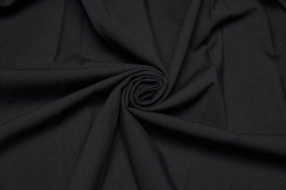 Close-up of black fabric showcasing soft texture, perfect for the Punk Rave Nyx Asymmetrical Shirt Dress.