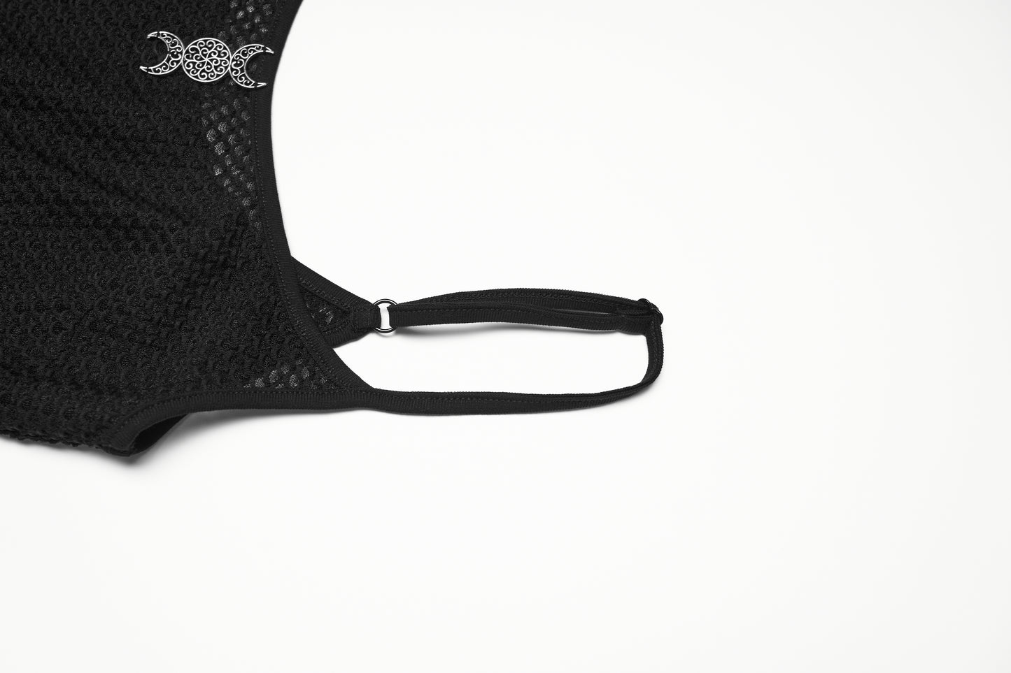 Close-up of a mesh goth camisole strap featuring a decorative moon motif, showcasing sheer black material.