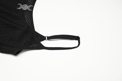Close-up of a mesh goth camisole strap featuring a decorative moon motif, showcasing sheer black material.