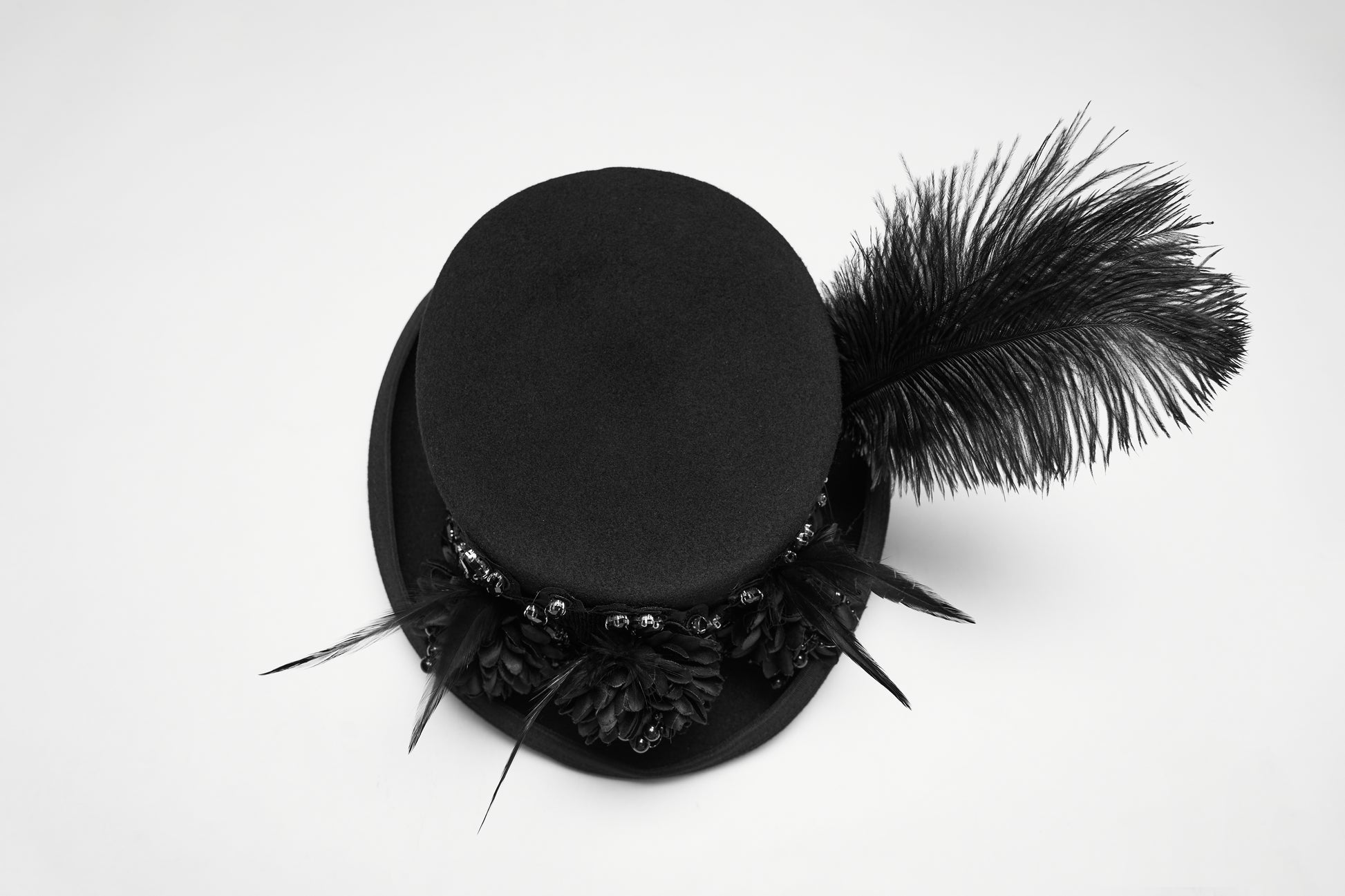Goth feather formal hat with feather and floral embellishments, perfect for alternative fashion. Bold and dramatic styling.