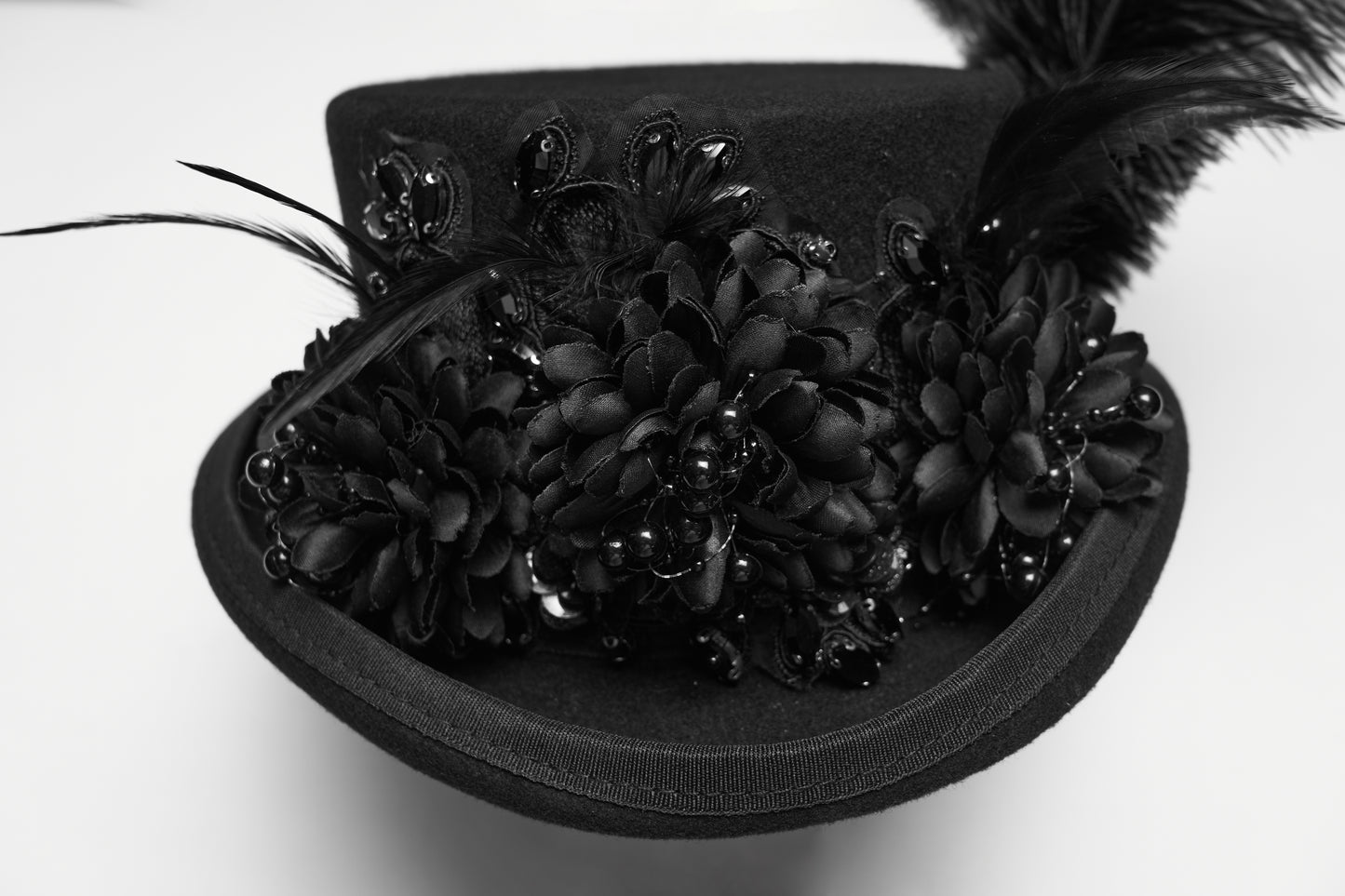 Goth feather formal hat featuring floral embellishments and layered feathers, perfect for gothic punk fashion.