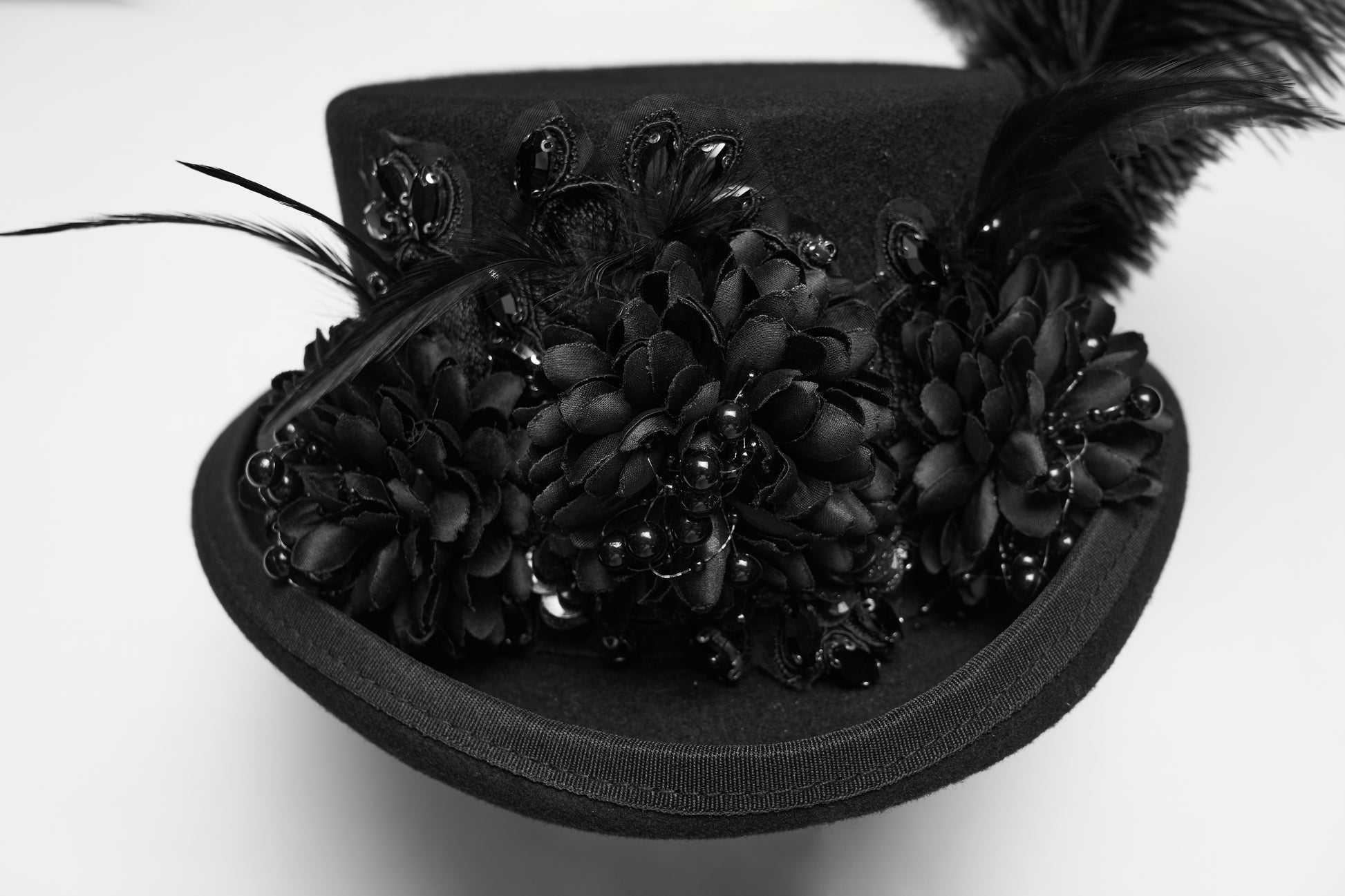 Goth feather formal hat featuring floral embellishments and layered feathers, perfect for gothic punk fashion.