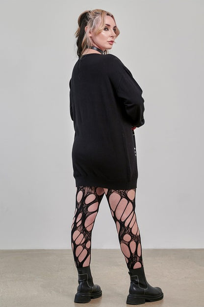 Model wearing a Gothic Jumper Dress in black with oversized fit paired with unique patterned tights.
