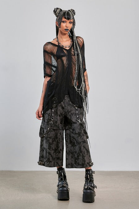 Gothic mesh top worn with oversized pants, showcasing a bold alternative style for layered fashion.