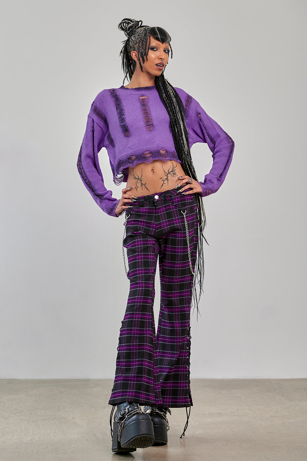 Model wearing Banned Apparel Purple Tartan Trousers front view scarlett vixen purple black tartan punk trousers with chains