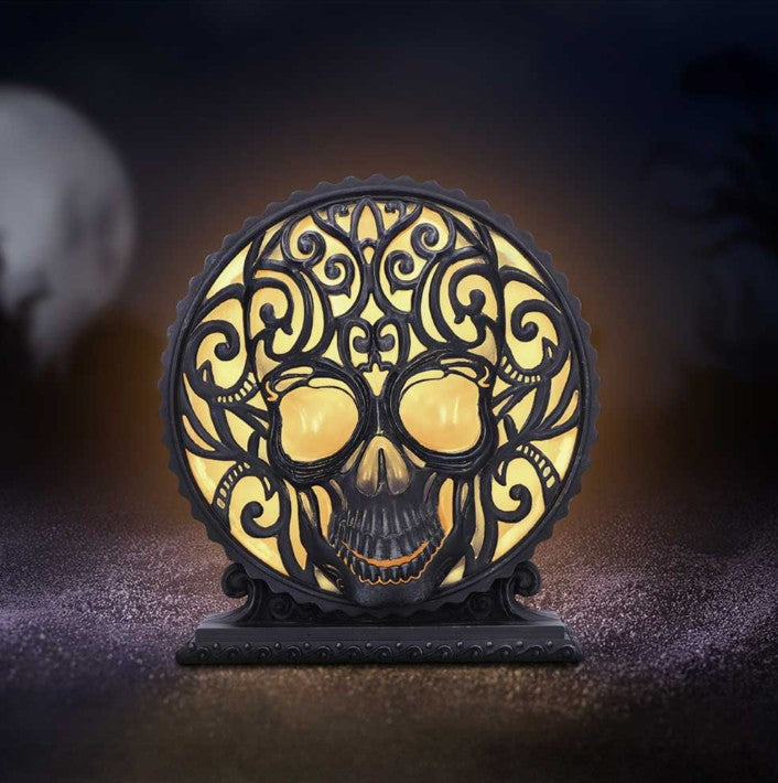 Decorative skull lamp with intricate designs on a dark background