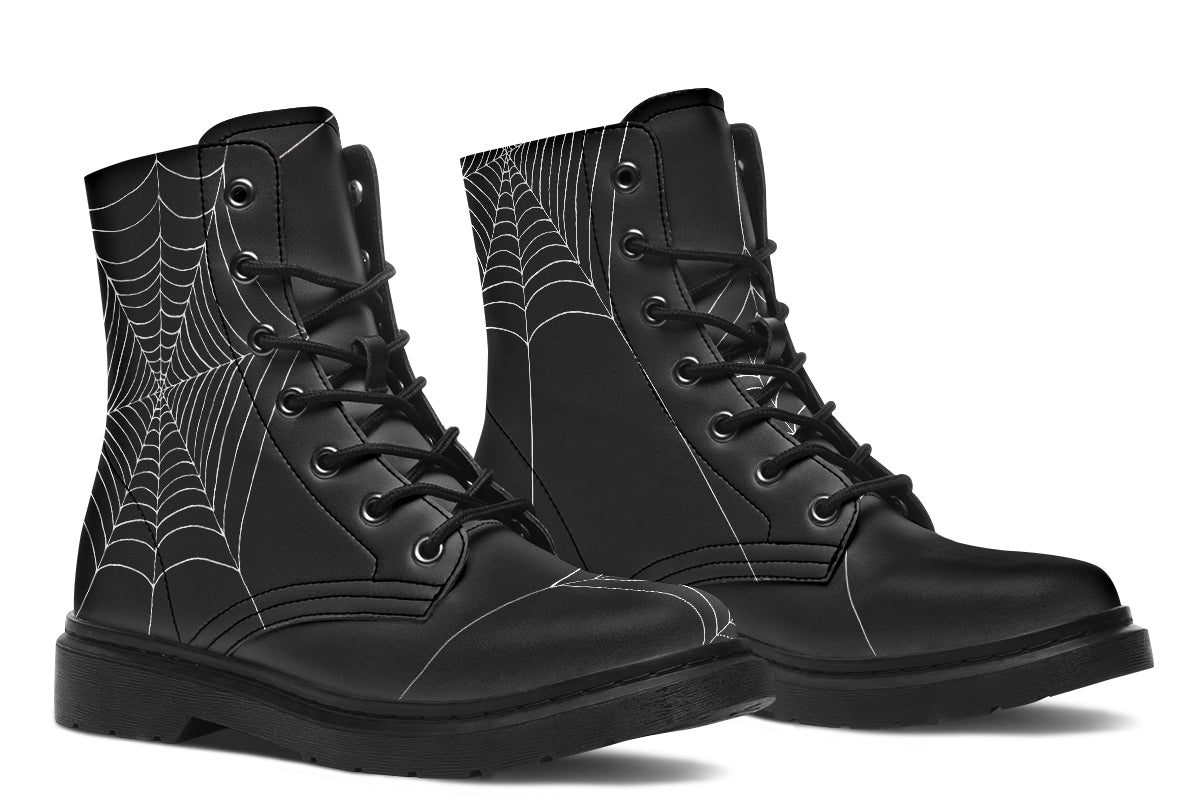 Black goth boots with spider web pattern on a white background