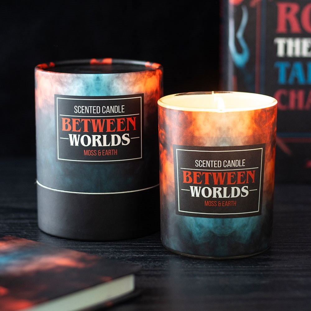 Scented candle labeled 'Between Worlds' with packaging on a dark surface.