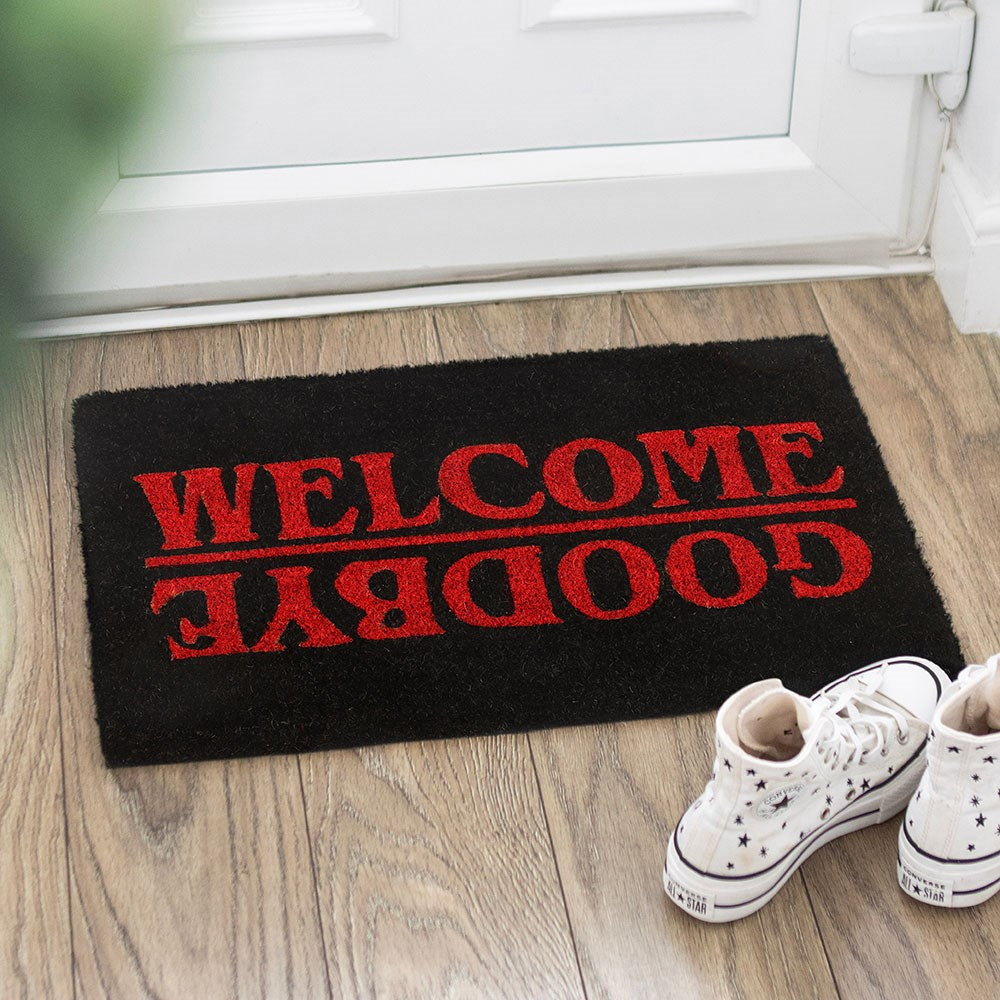 Gothic Doormat with red lettering that reads 'WELCOME' and 'GOODBYE' on a black background.
