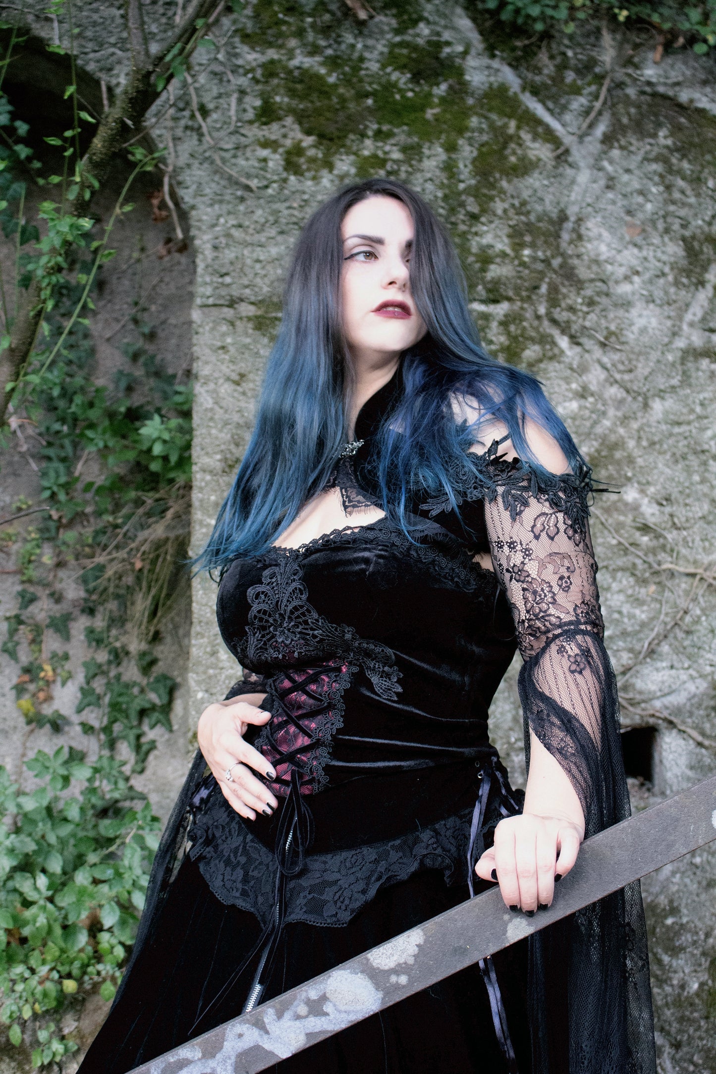 Angelineva_ wearing Dark in Love Gothic Velvet Corset Top stood against a stone wall