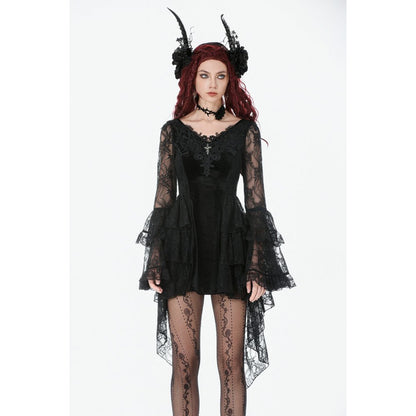 Gothic model wearing a black lace dress with long sleeves and sheer tights on a white background