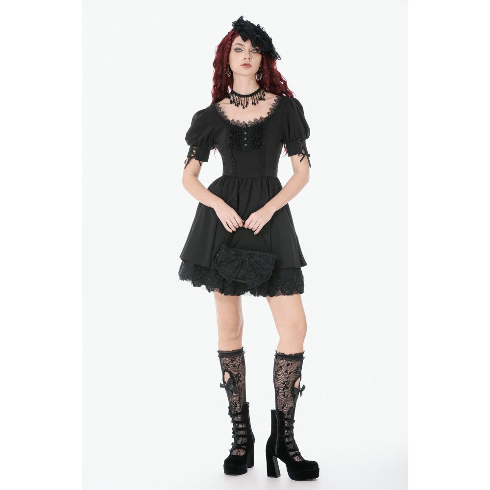 Woman wearing a black lace dress with matching accessories on a white background