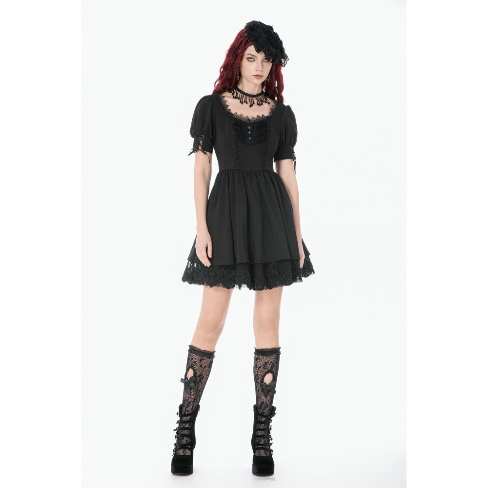 Woman wearing a black lace dress and boots on a white background