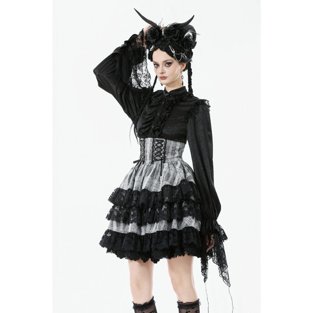 Person wearing a black and white gothic outfit with a headpiece on a white background