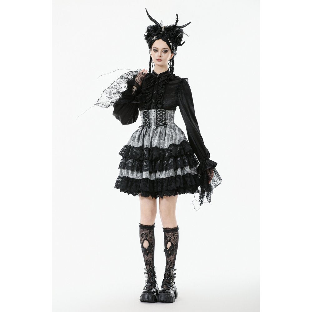 Person wearing a black and white gothic outfit with lace details on a white background