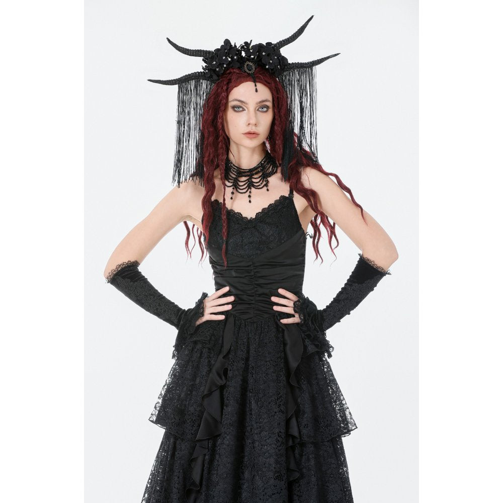 Woman in a black gothic dress with horns and gloves on a white background