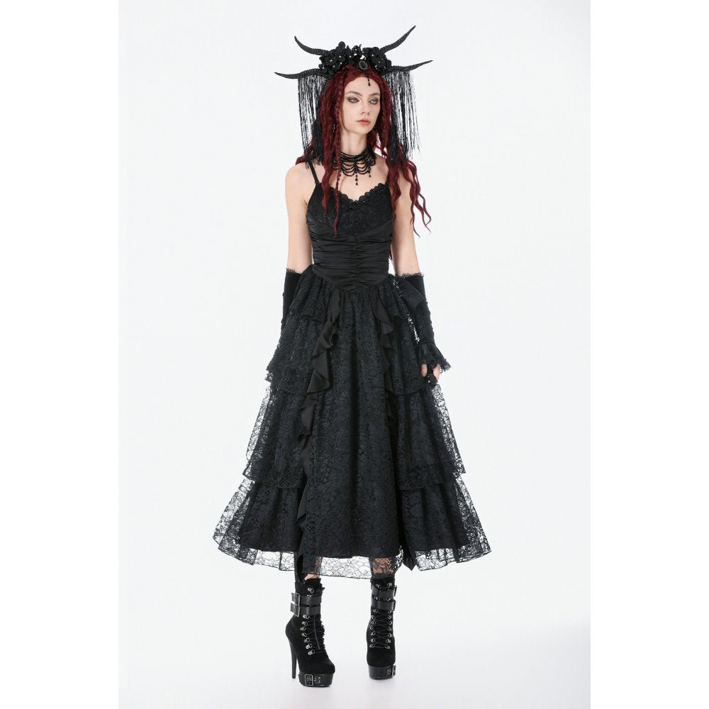 Person wearing a black gothic dress with a veil and horns on a white background
