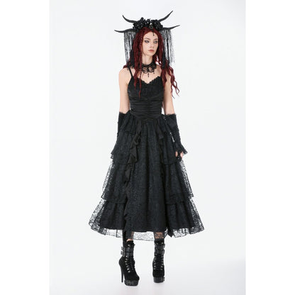 Person wearing a black gothic dress with a veil and horns on a white background