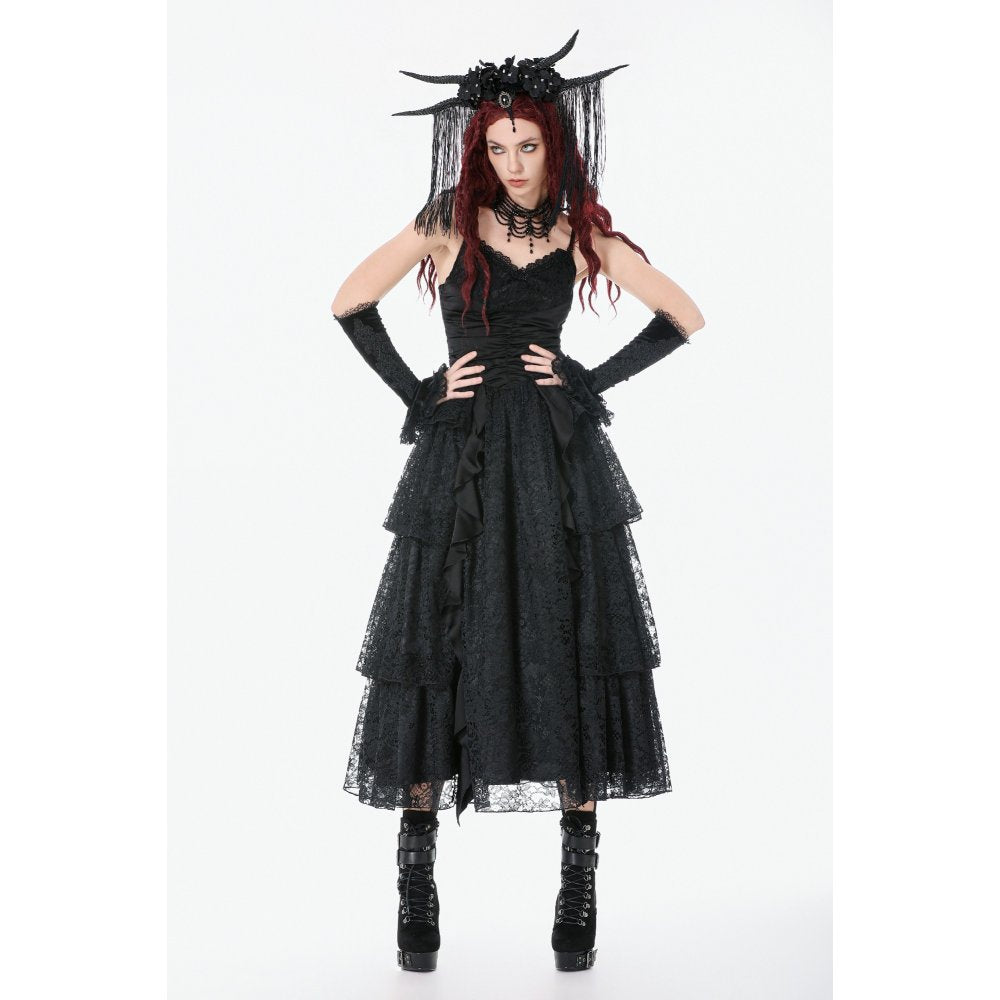 Model wearing a black gothic dress with ruffles and a headpiece on a white background