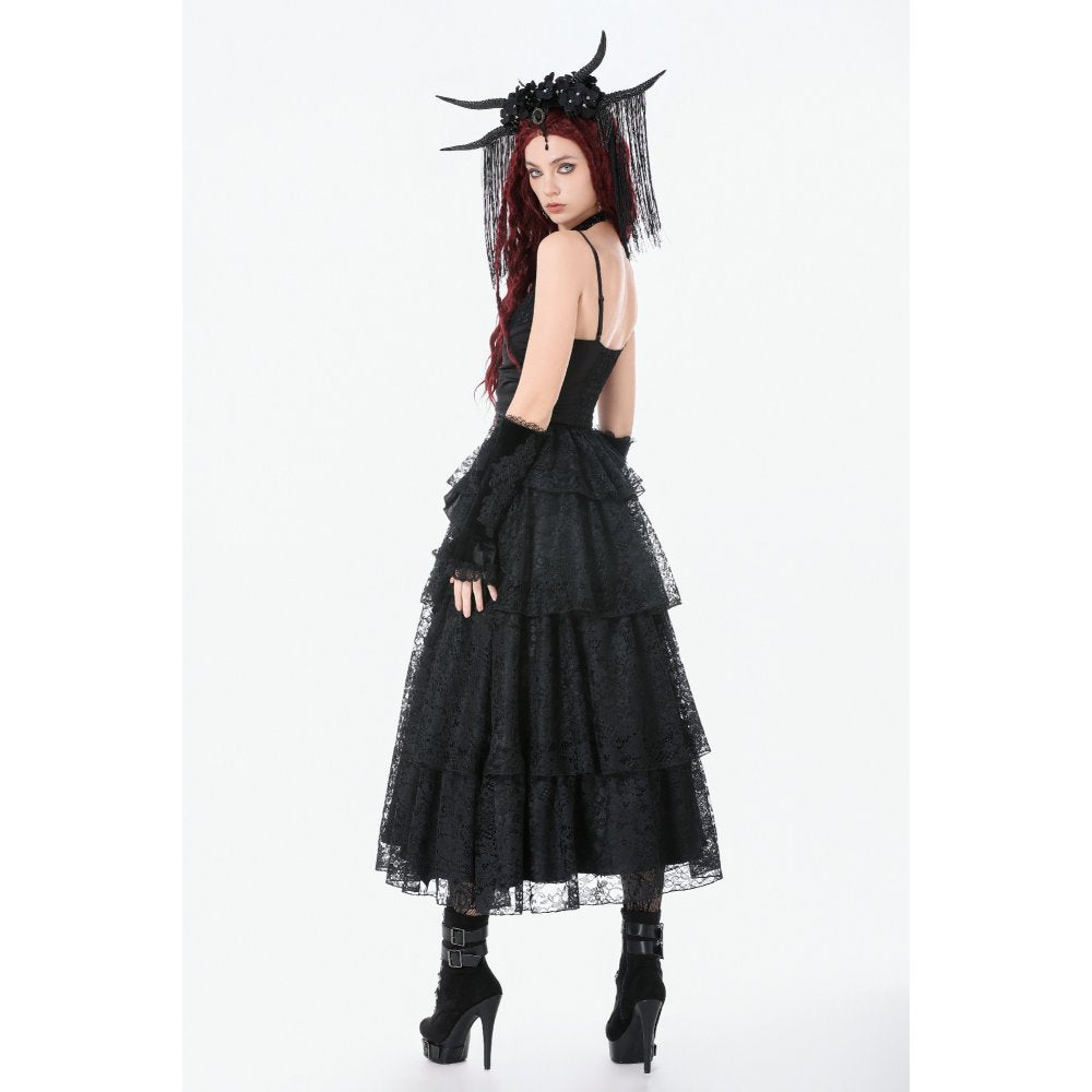 Model wearing a black gothic-style dress with layered lace skirt and headpiece on a white background