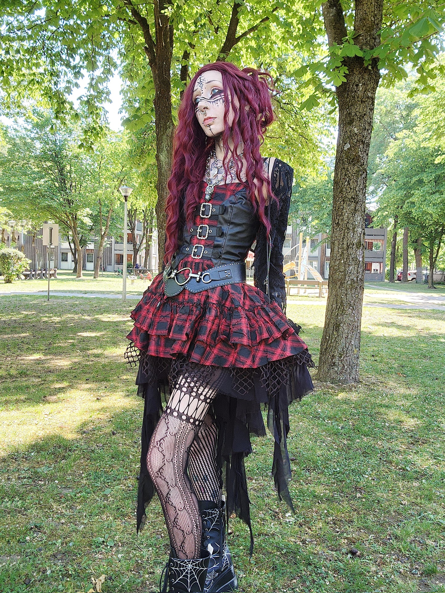 Valentinescorpse wearing Dark in Love Red-Black Tartan Alternative Dress in amongst some trees