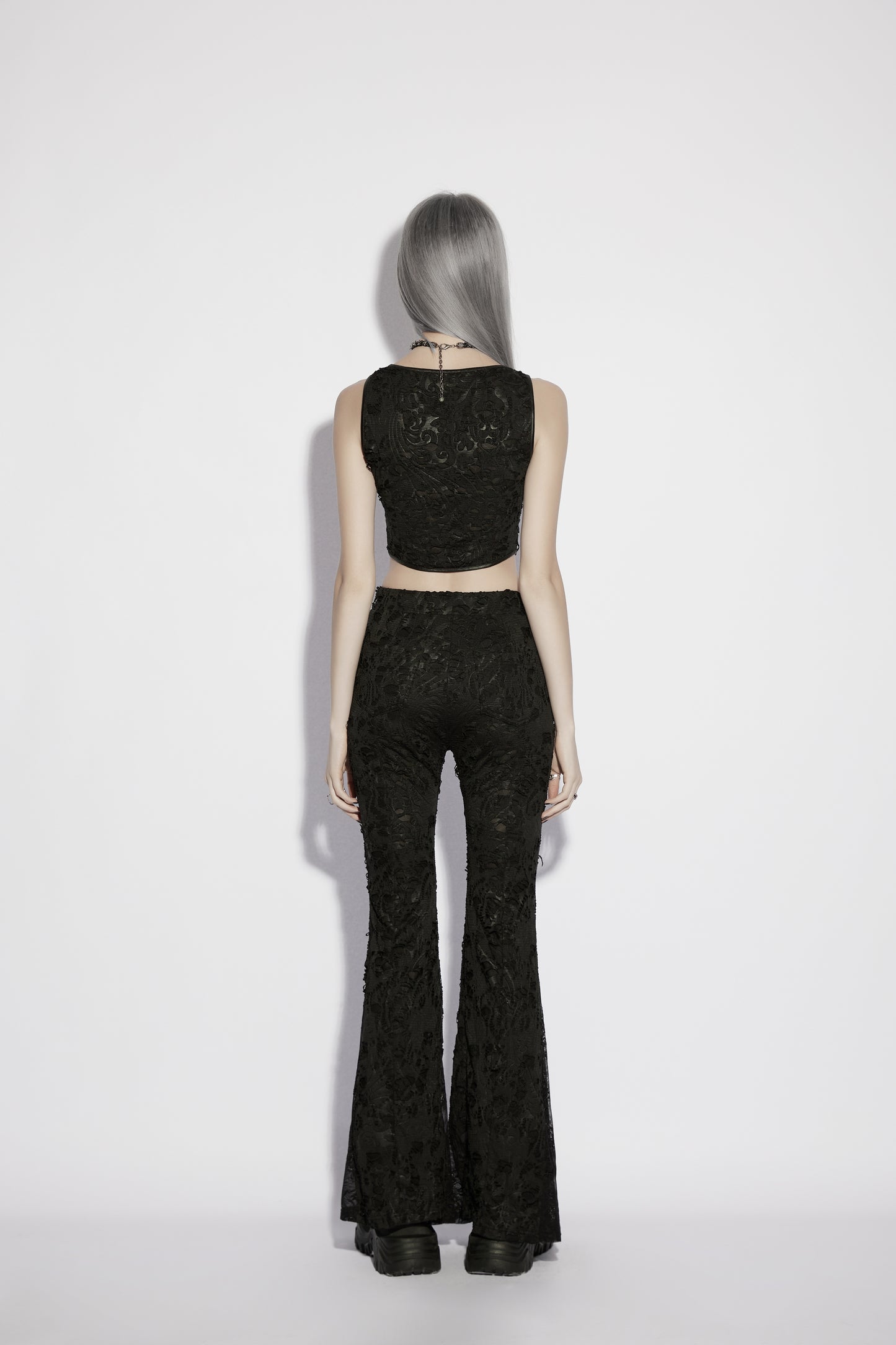 Model wearing Punk Rave Morticia Jacquard Flared Pants and a black crop top from the back, showcasing dark elegance.