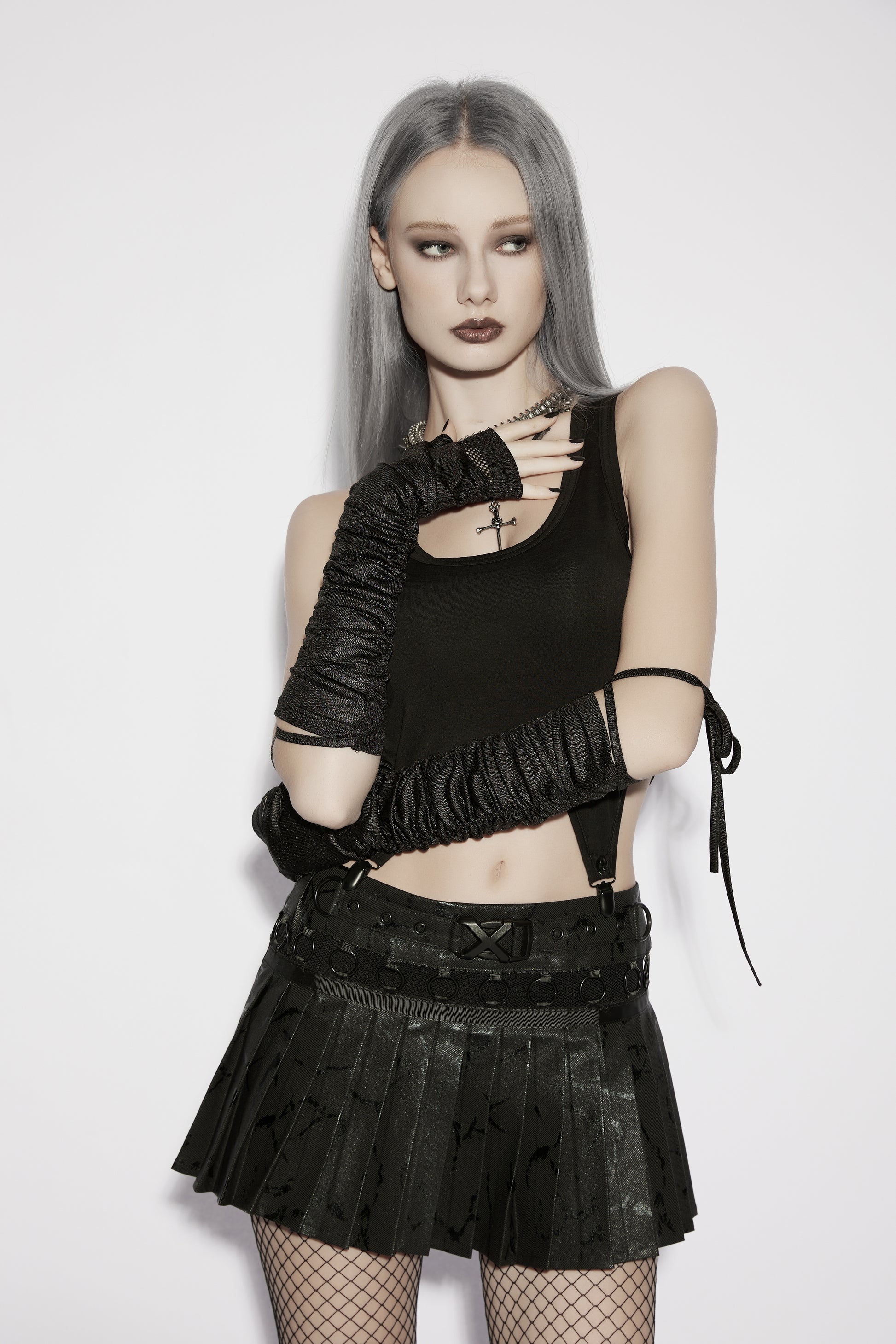 Model wearing goth fingerless strap gloves paired with a black pleated skirt and tank top, showcasing a punk aesthetic.
