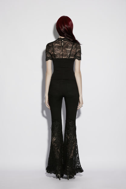 Back view of a model in a black lace panel goth t shirt and flared lace pants.