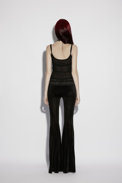 Back view of a model wearing a mesh goth camisole paired with flared black pants, showcasing gothic style.