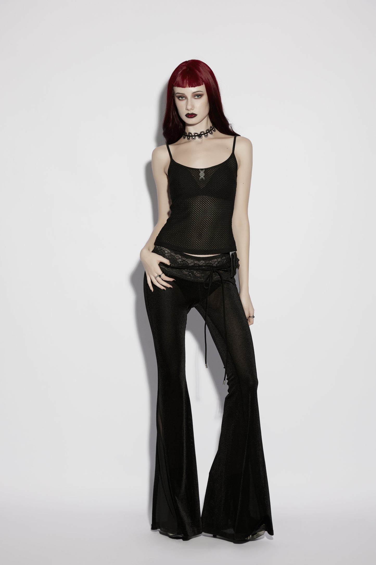 Model wearing Punk Rave Lilith Low Waist Flared Pants paired with a sheer black top and accessories.