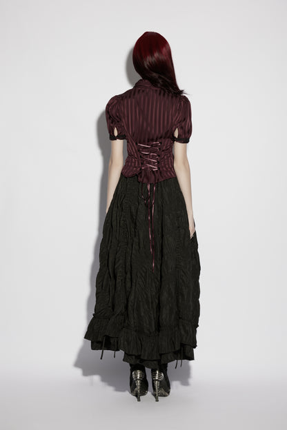 Back view of a model wearing the Punk Rave Morrigan Goth Pleated Retro Skirt paired with a dark striped top.