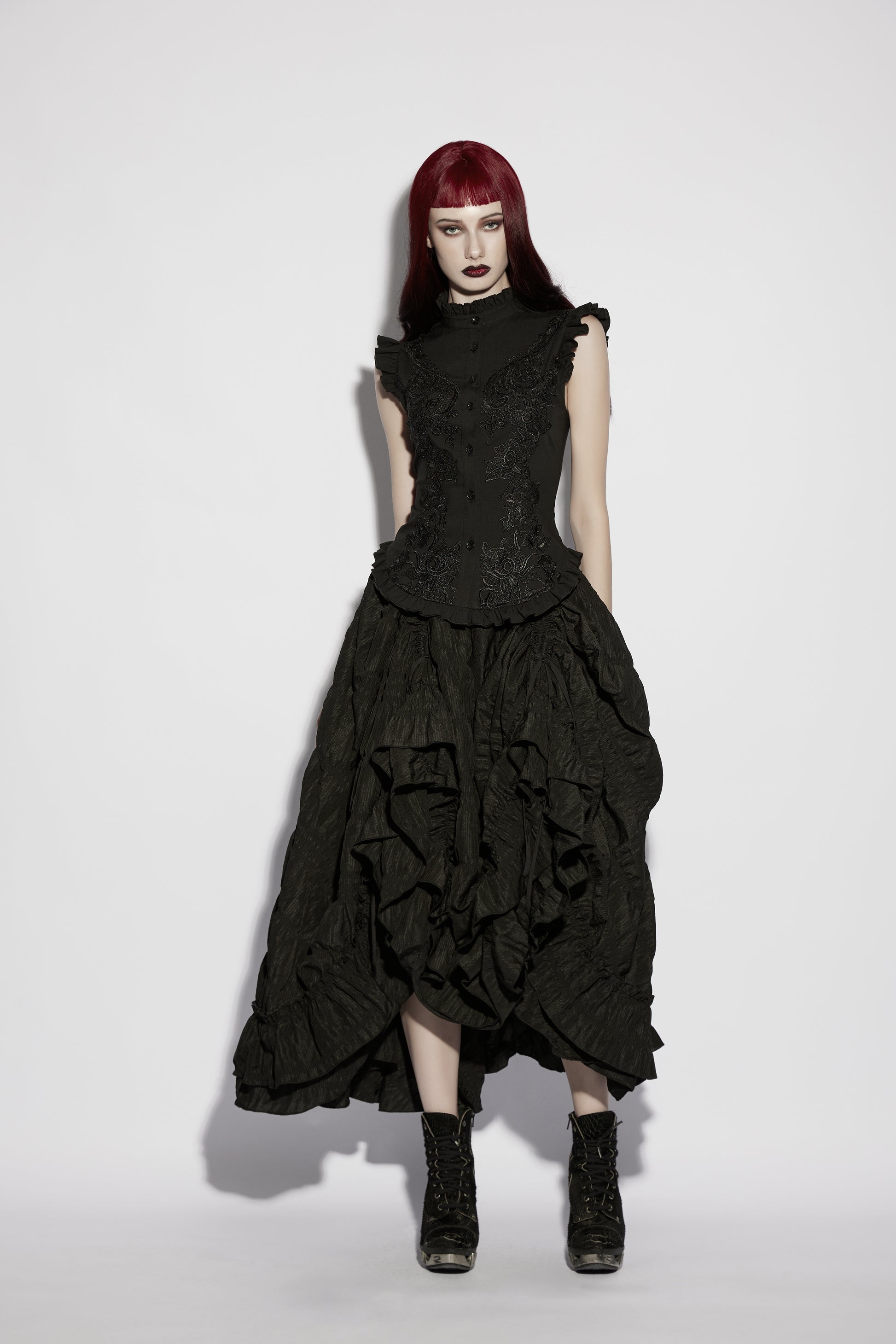 Goth ruffle shirt showcasing a model in a dramatic black outfit with ruffles, blending structured elegance and gothic style.