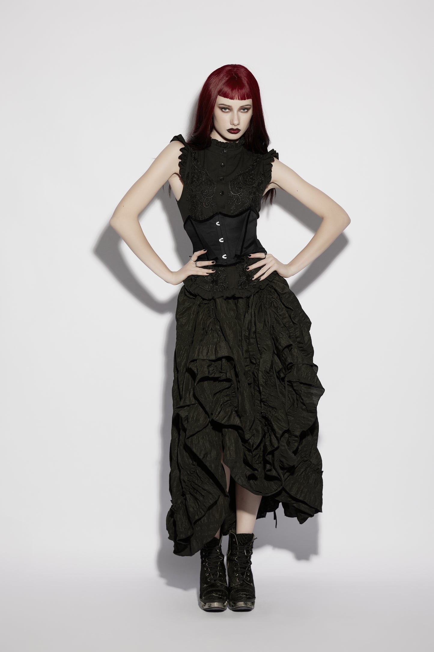 Model wearing Punk Rave Morrigan Goth Pleated Retro Skirt paired with a corset and edgy footwear, showcasing gothic fashion.