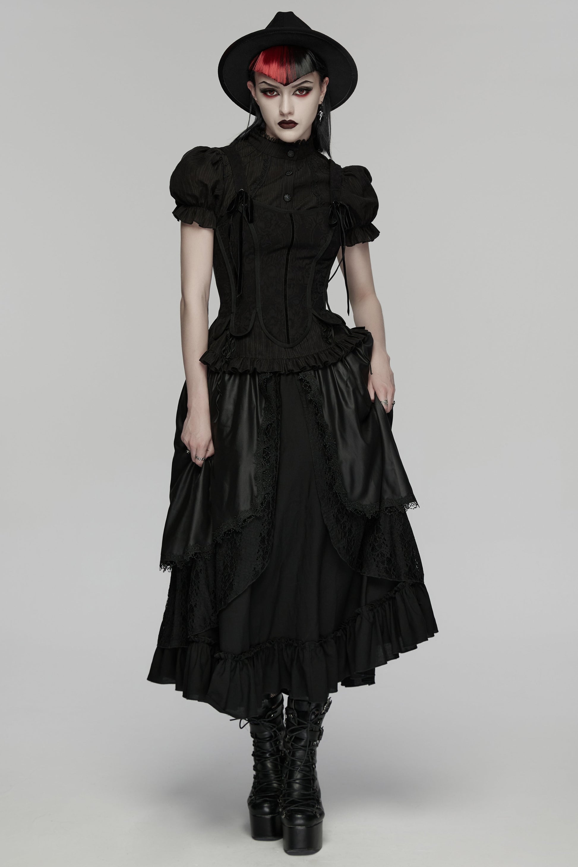 Model wearing a goth layered skirt with a dark romantic texture, complemented by a black hat and boots.
