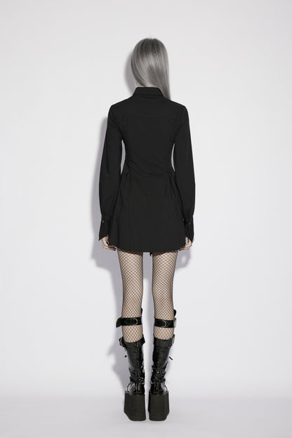 Back view of a model wearing the Punk Rave Nyx Asymmetrical Shirt Dress with fishnet tights and platform boots.