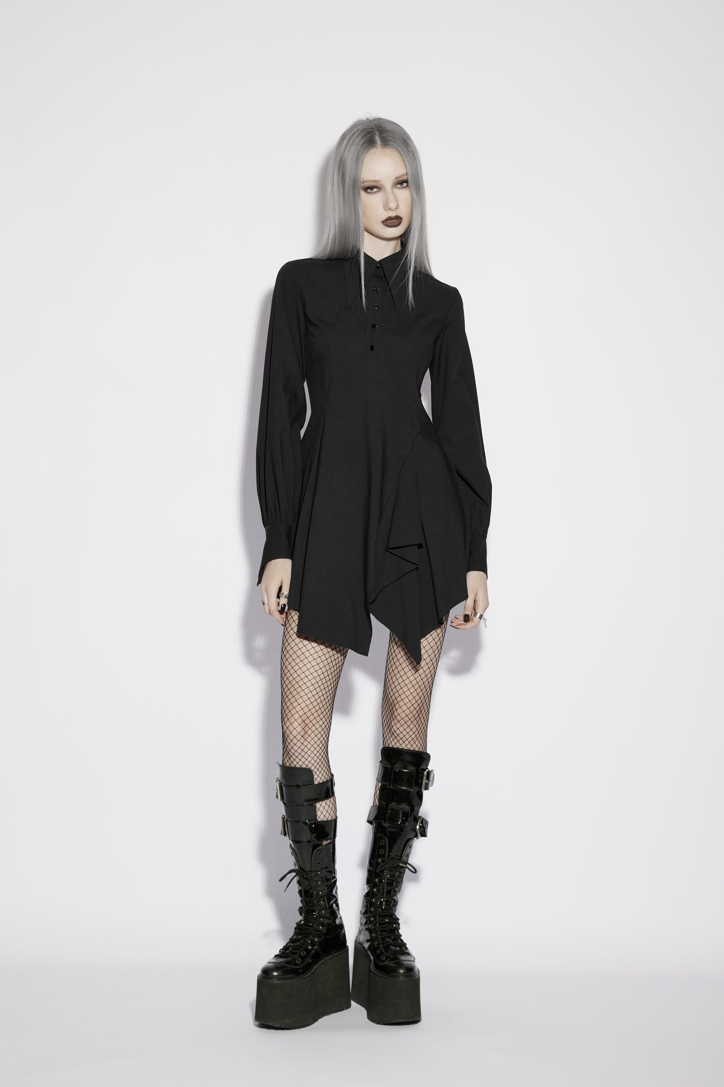 Model wearing the Punk Rave Nyx Asymmetrical Shirt Dress, showcasing a gothic style with dramatic tailoring and edgy footwear.