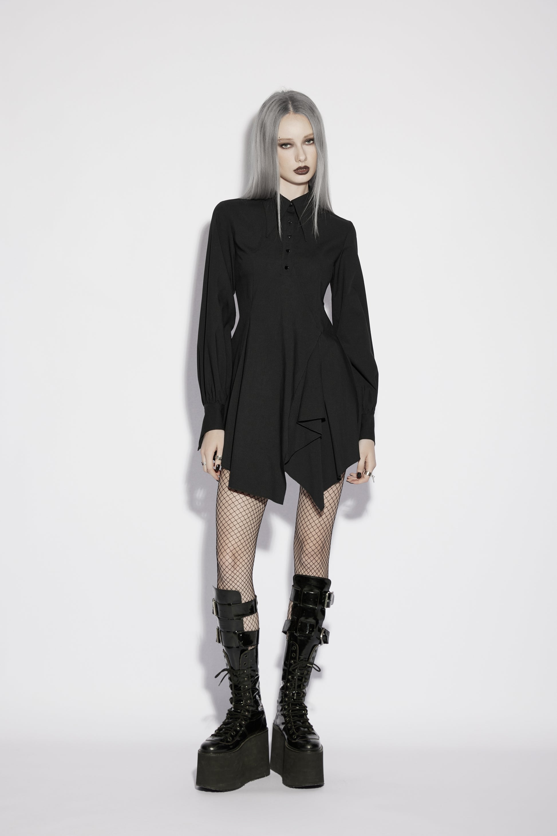 Model wearing the Punk Rave Nyx Asymmetrical Shirt Dress, showcasing a gothic style with dramatic tailoring and edgy footwear.