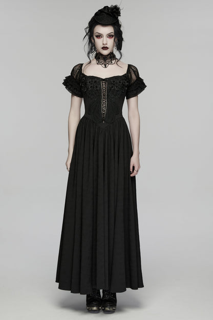 Woman wearing a black gothic-style dress on a gray background