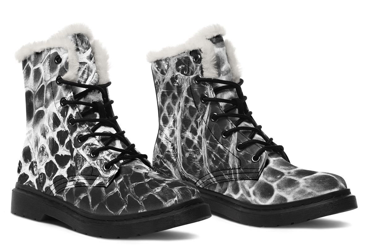 Pair of black and white patterned boots with fur lining on a white background