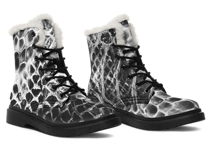 Pair of black and white patterned boots with fur lining on a white background
