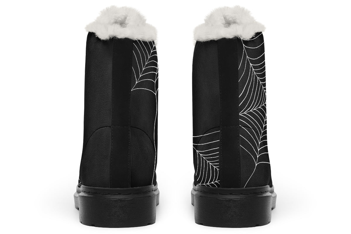 Black boots with spider web design and white fur lining on a white background