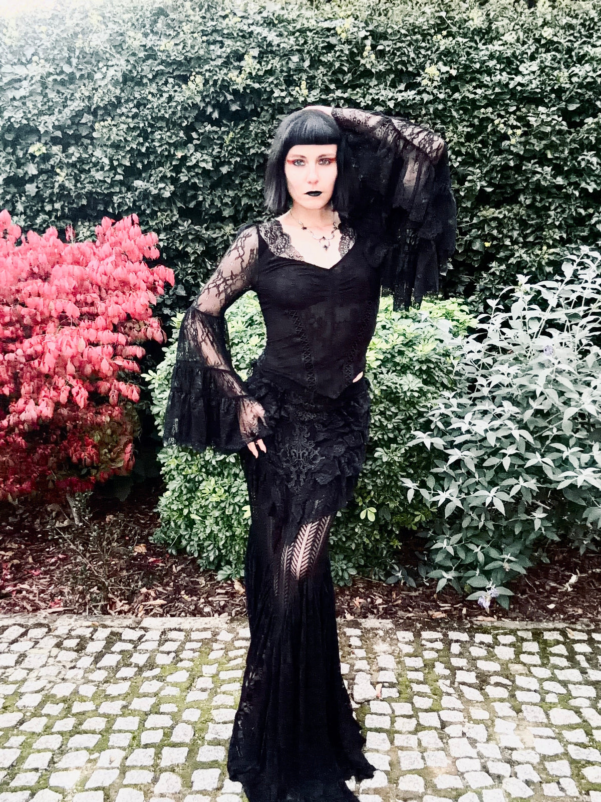 Julia Rose Noir wearing the Punk Rave Rowena Gothic Fishtail Maxi Skirt with the Dark in Love Zuri Gothic Bell Sleeve Top showcasing the lace belled sleeves