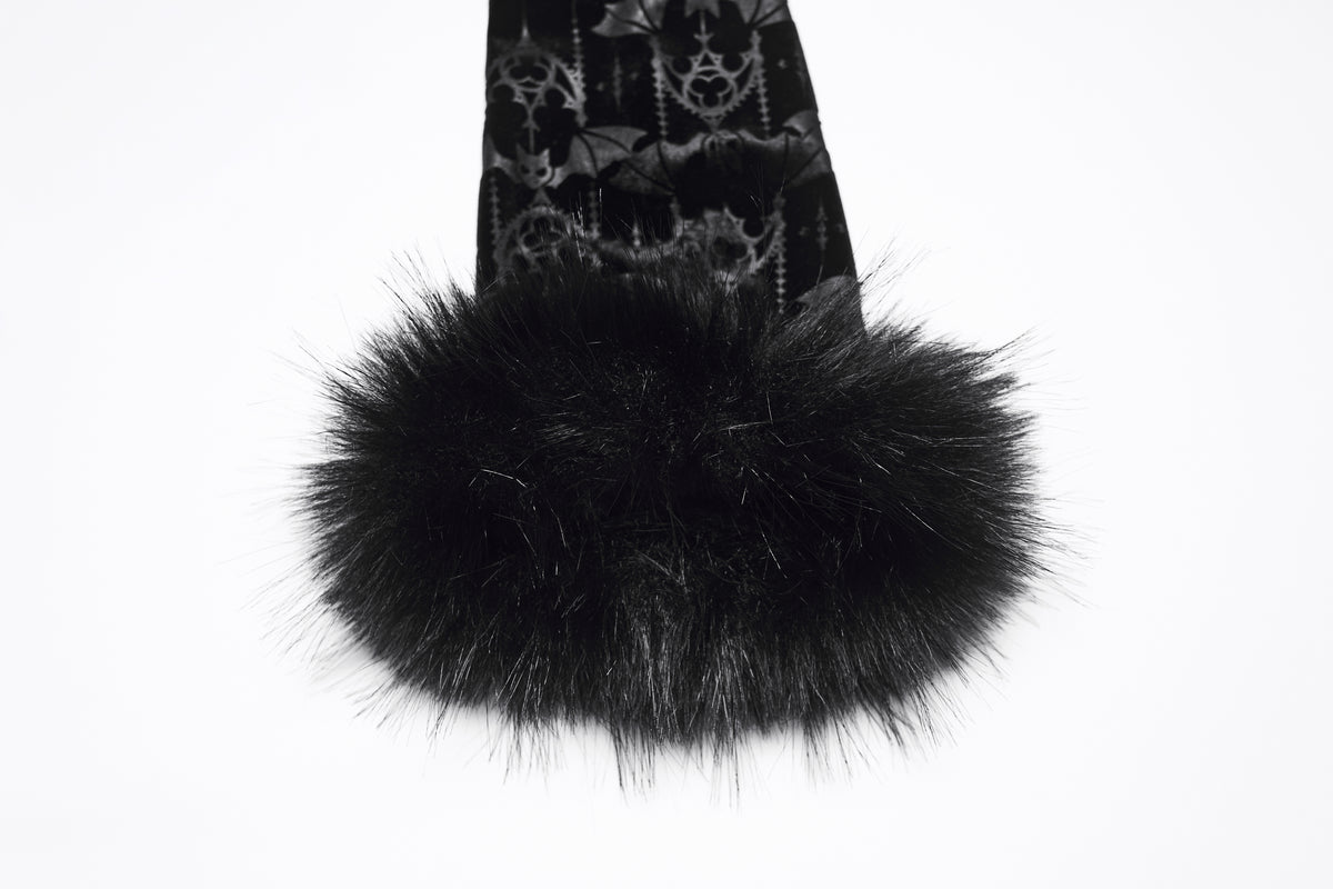 A close-up of a black faux fur trim attached to a black fabric sleeve with a gothic pattern of cathedrals and bats, set against a plain white background.