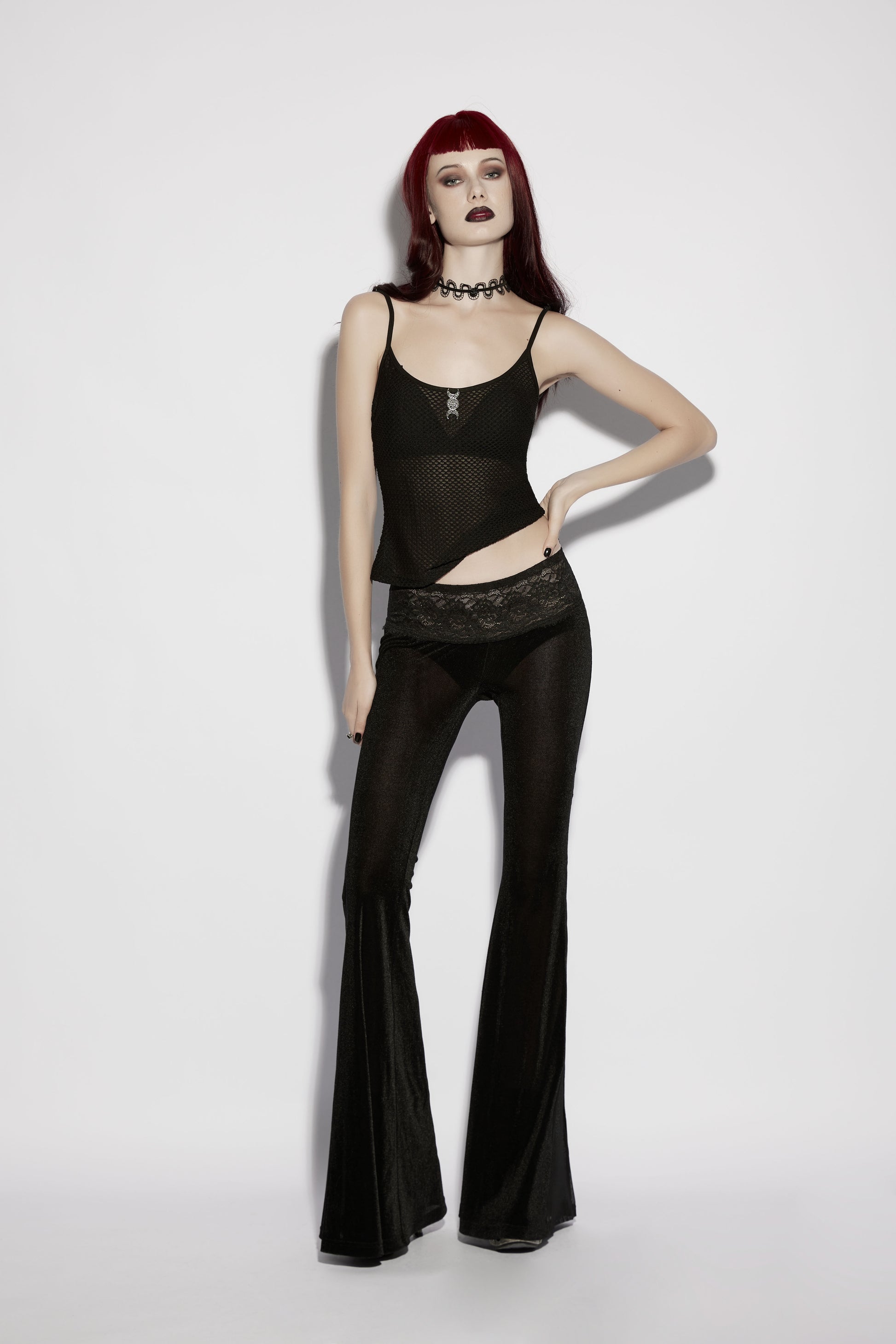 Model wearing Punk Rave Lilith Low Waist Flared Pants paired with a sheer top, showcasing gothic fashion style.
